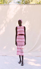 Woman wearing a pink dress with a white background