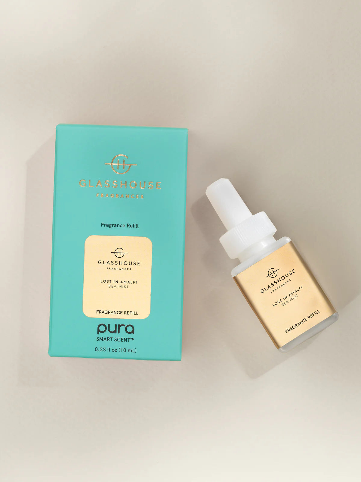 Glasshouse Fragrances Pura smart scent refill bottle and packaging on a beige background