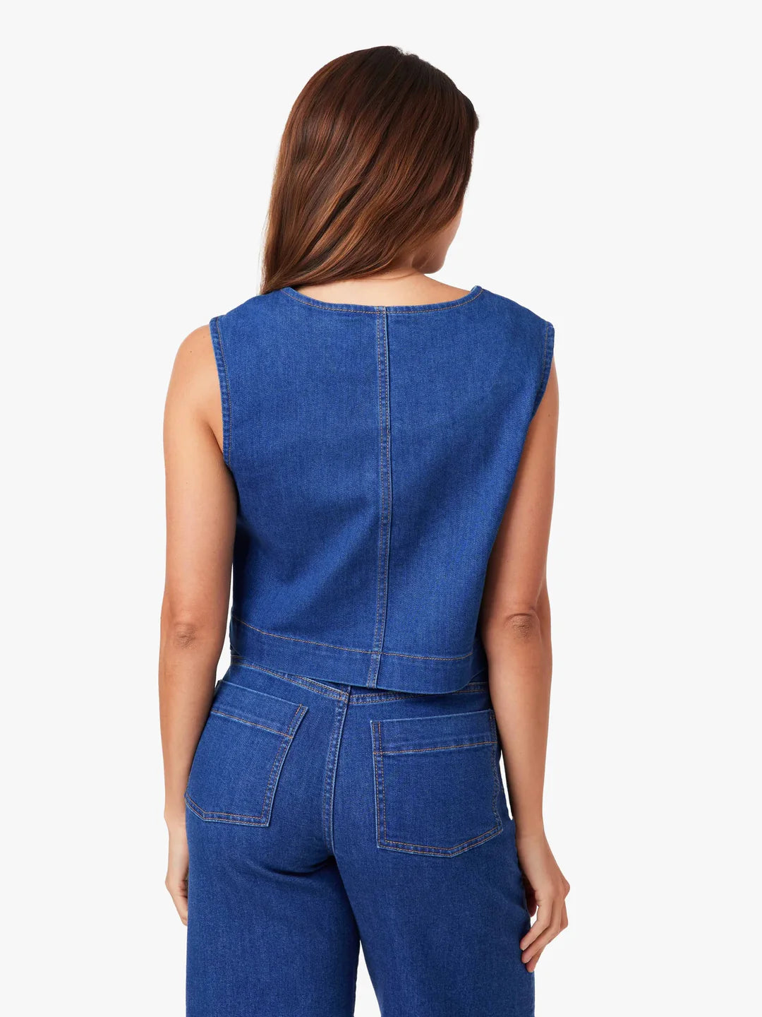 Woman wearing a blue jumpsuit against a plain background