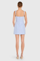 Woman wearing a light blue checkered dress on a white background