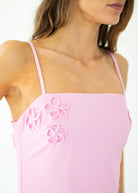 Pink top with floral embroidery on a white background