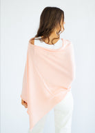 Woman wearing a pastel pink and green gradient shawl on a white background