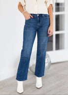 Person wearing blue jeans and a white shirt in an indoor setting