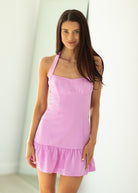 Woman wearing a pink dress against a white background