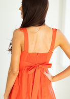 Orange dress with a bow detail on a white background