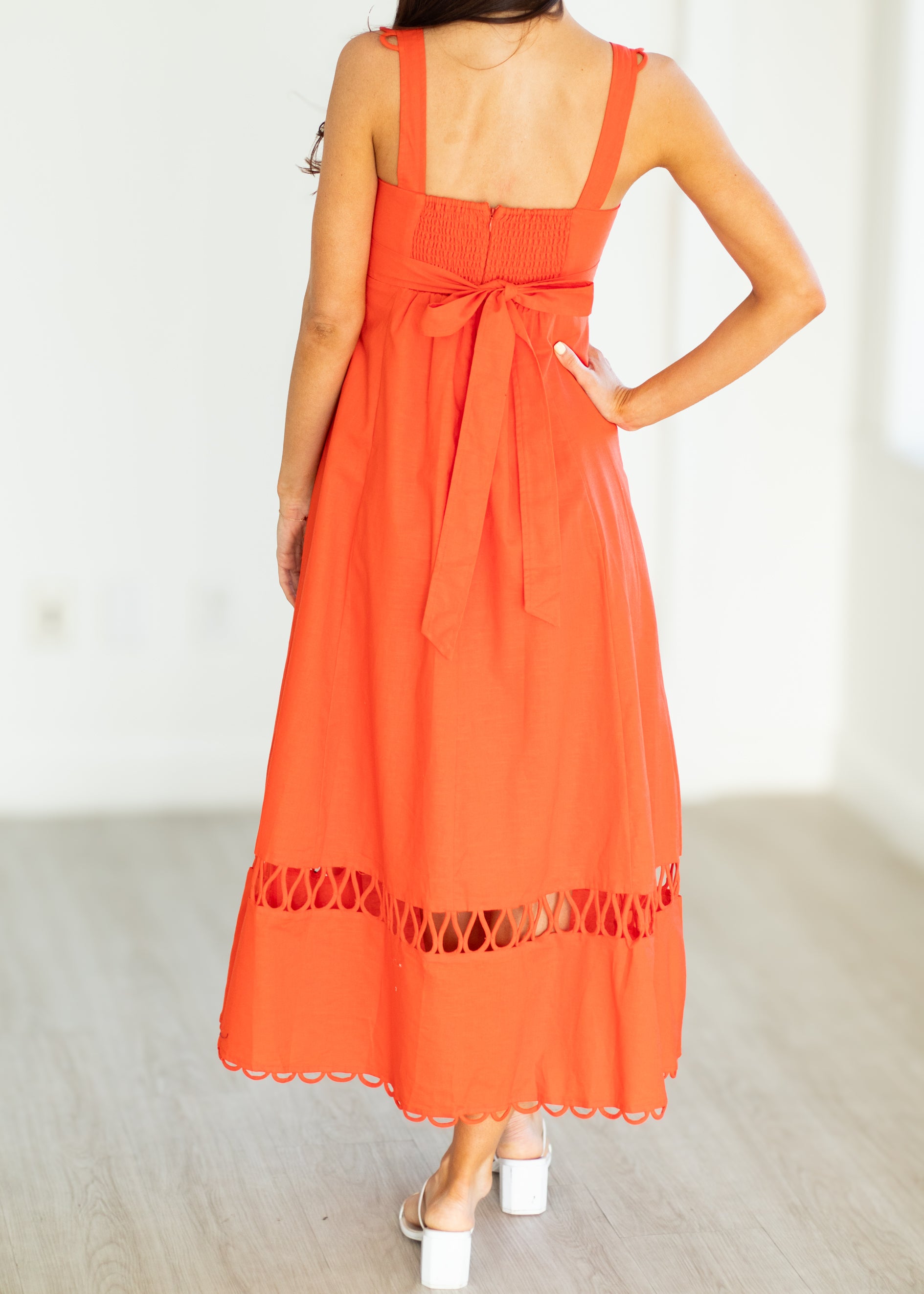 Orange dress with lace details on a plain background