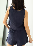 Person wearing a navy blue romper with a blurred background