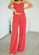 Red checkered outfit with a strapless top and wide-leg pants on a neutral background