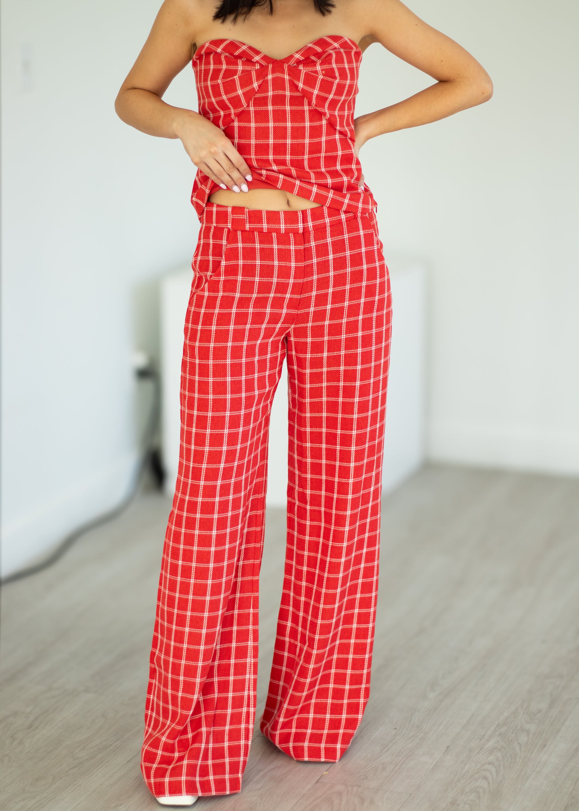 Red checkered outfit with a strapless top and wide-leg pants on a neutral background