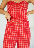 Red plaid jumpsuit worn by a person on a light gray background