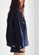 Person wearing a blue denim jacket against a white background