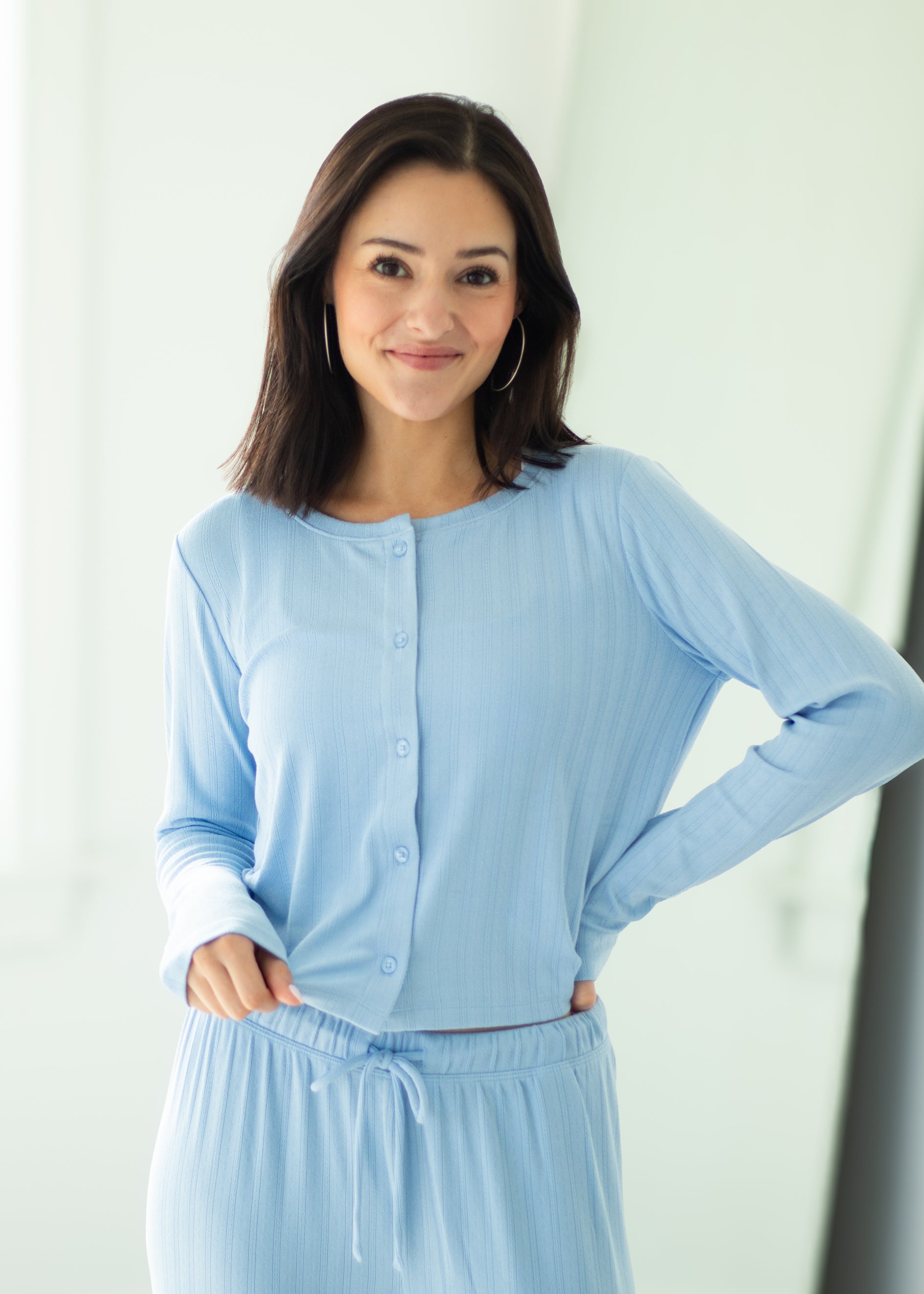 Woman wearing a light blue outfit against a white background