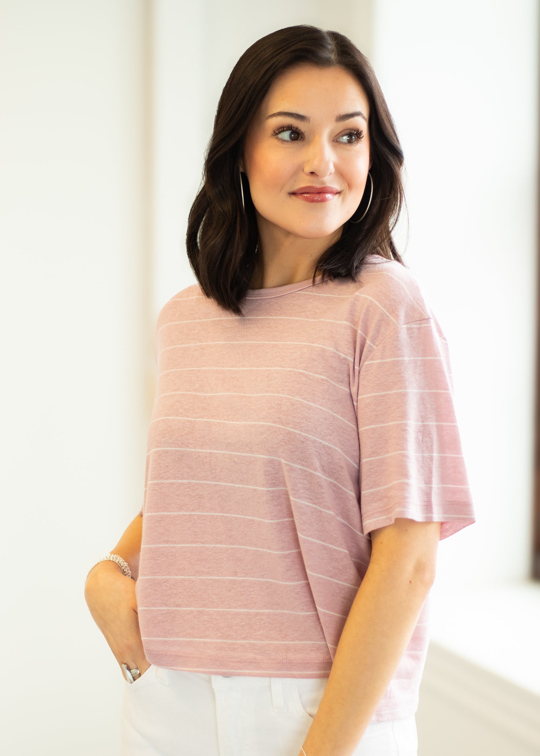 Woman wearing a pink striped shirt against a white background