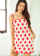Woman wearing a red and white patterned dress against a neutral background