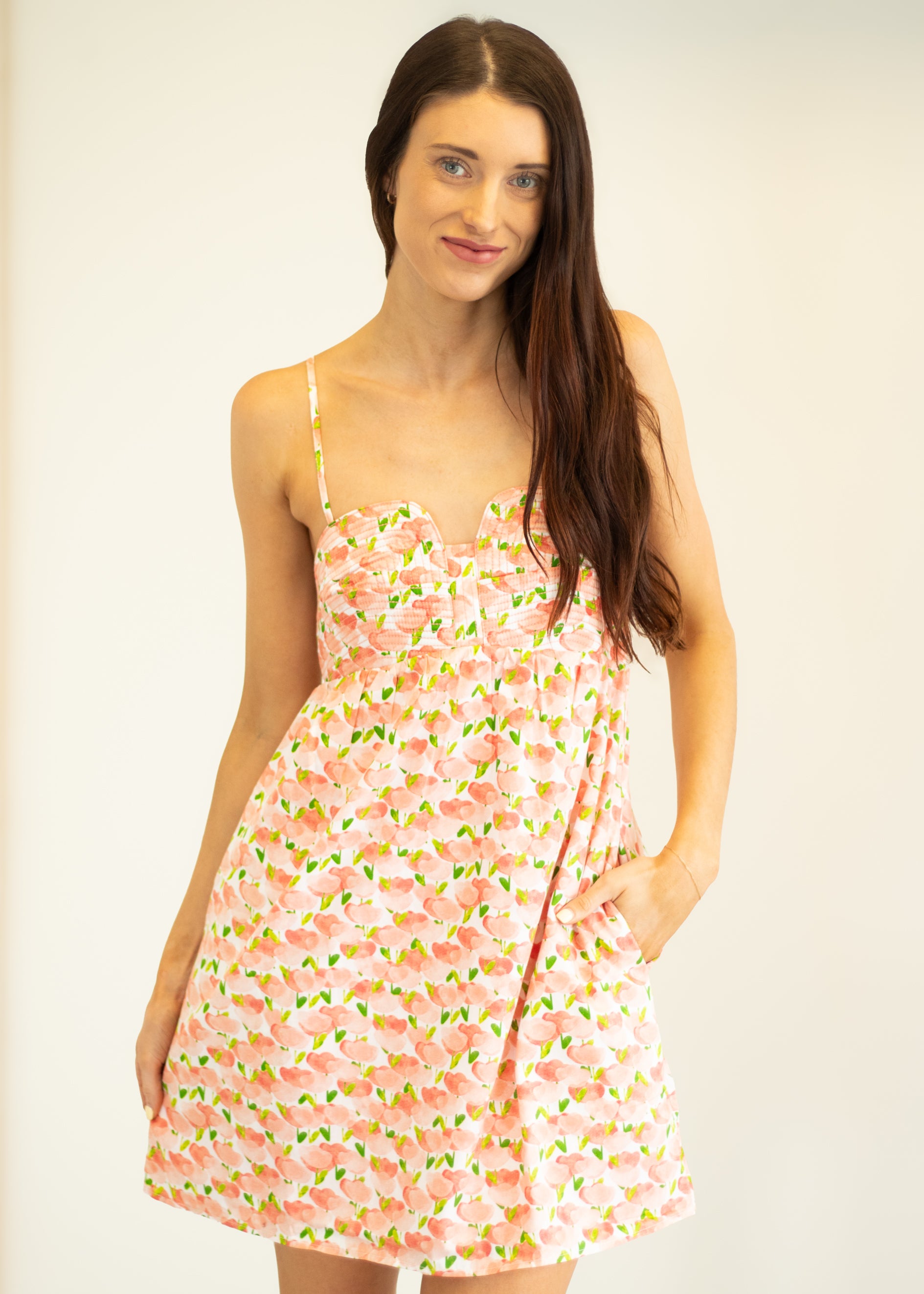 Woman wearing a floral dress against a plain background