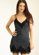 Woman wearing a black lace nightgown against a white background