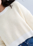 Close-up of a person wearing a white and yellow striped sweater with a blurred background