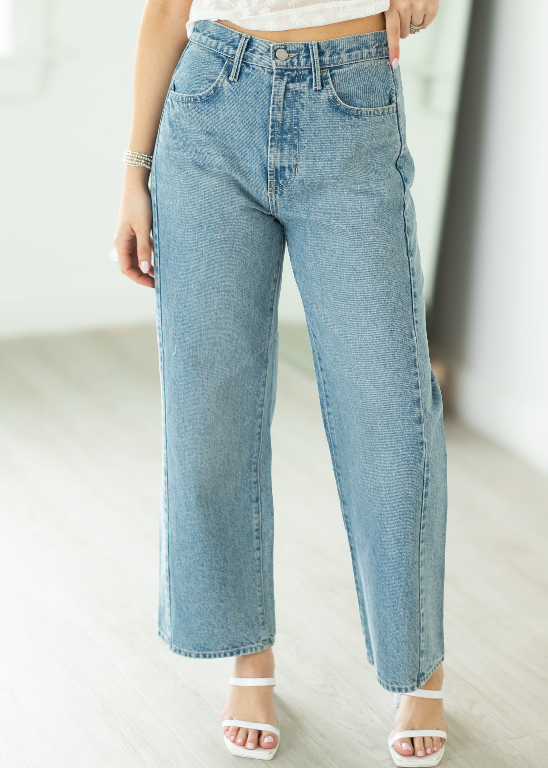 Light blue jeans worn by a person on a plain background