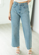 Light blue jeans worn by a person on a plain background