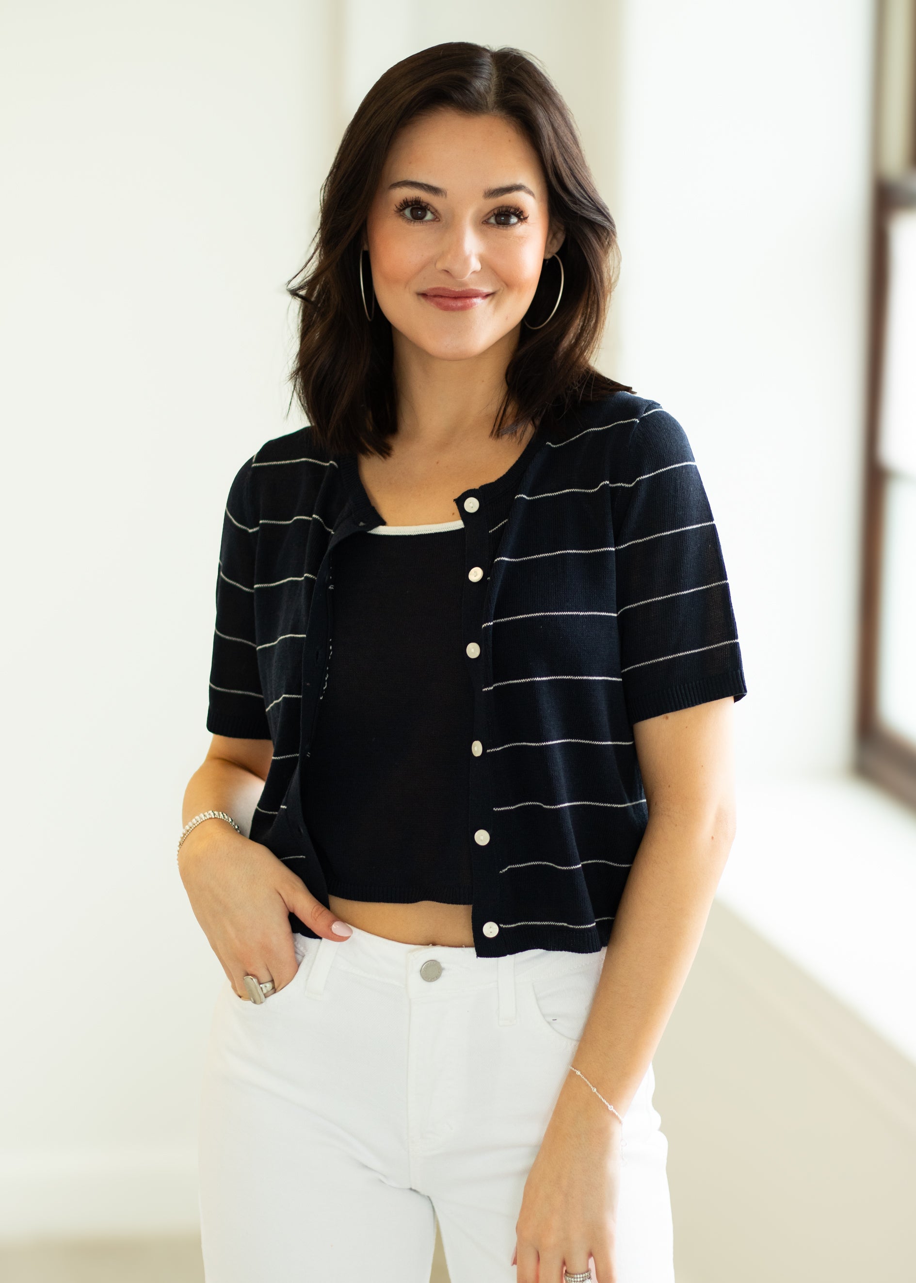 Woman wearing a black and white striped shirt with a plain background