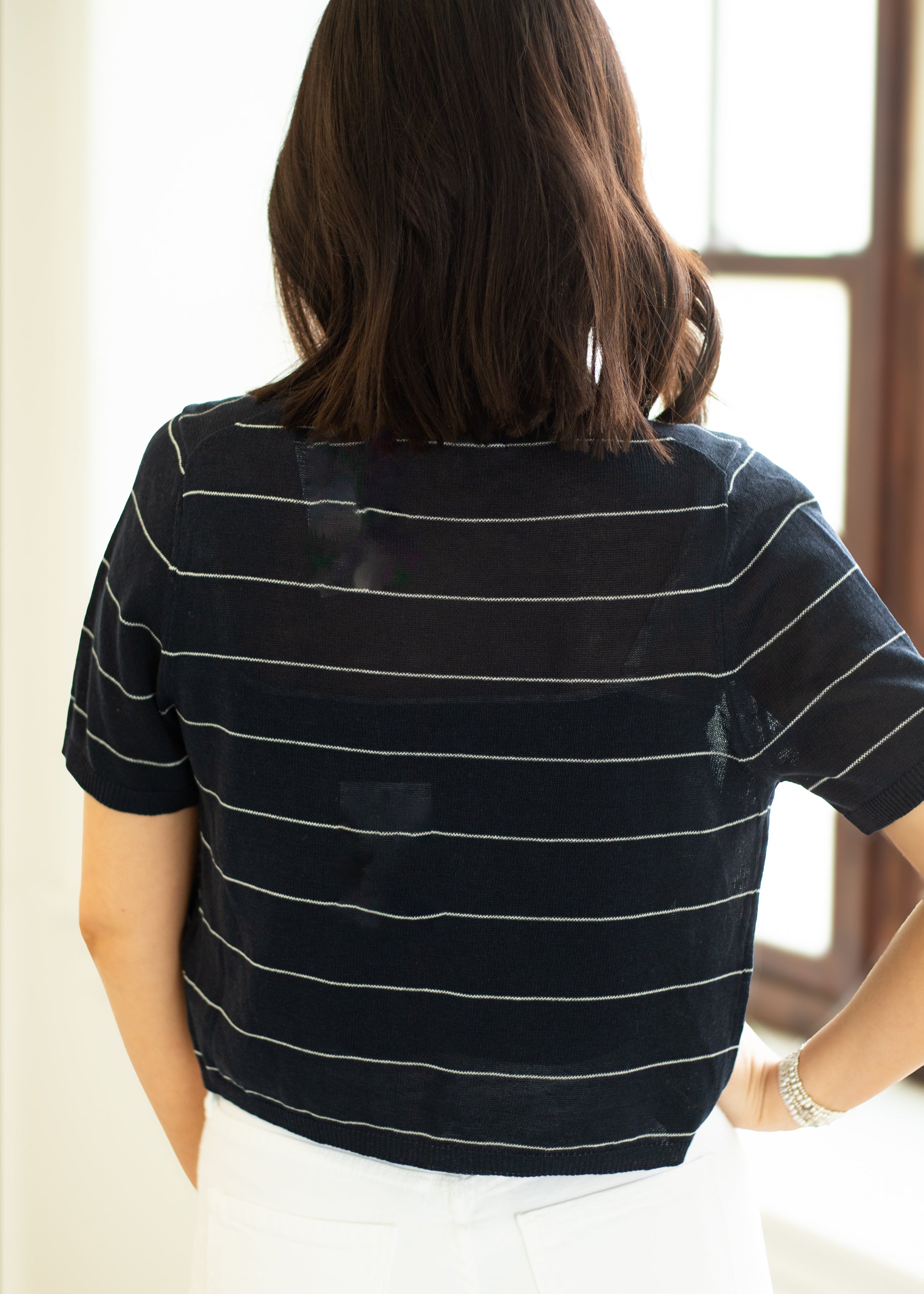 Person wearing a black and white striped shirt with a blurred background