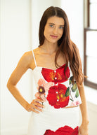 Woman wearing a white top with red floral design indoors