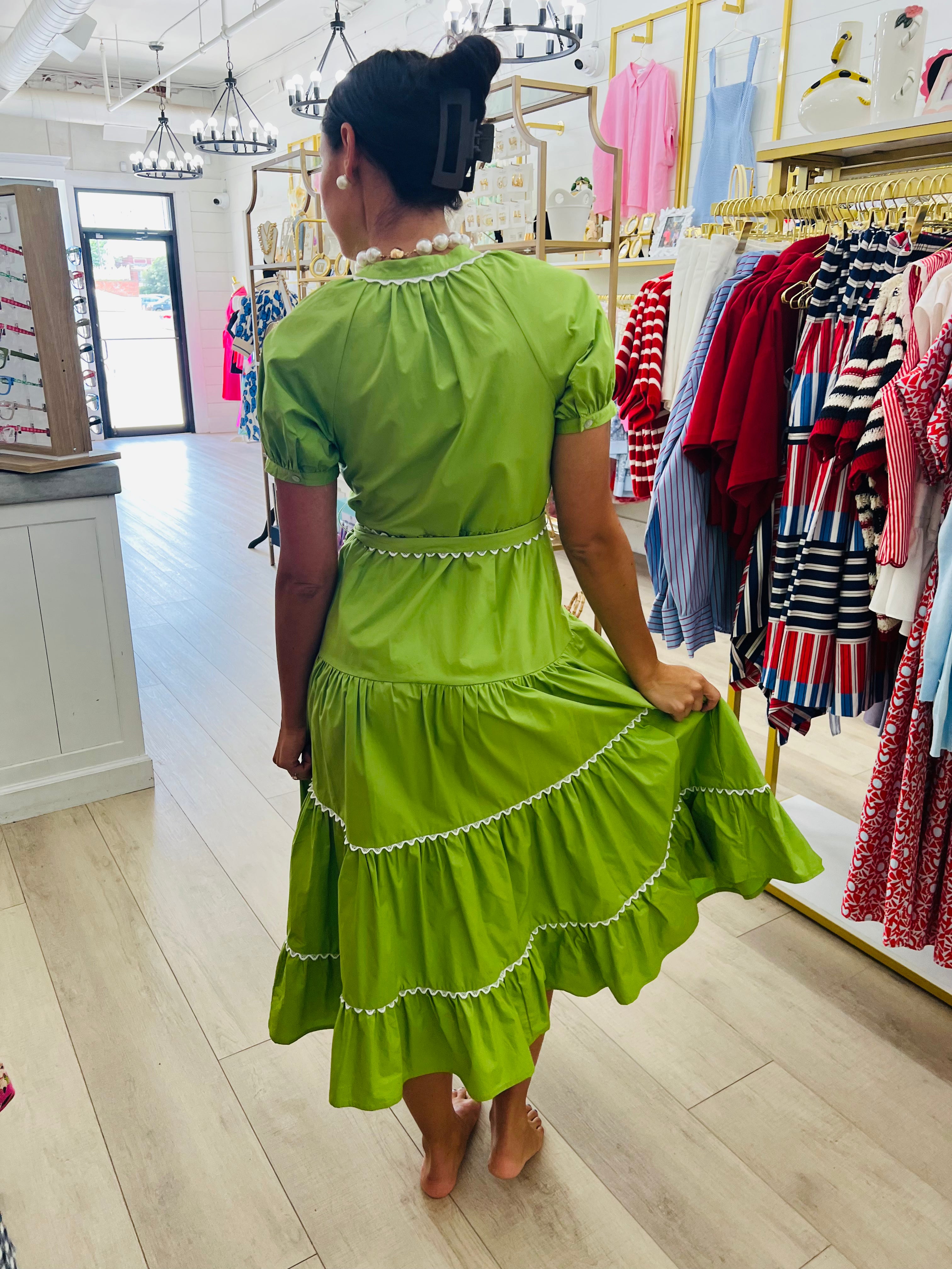 Woman in a green dress standing in a clothing store