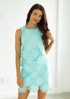 Woman wearing a light blue lace dress against a white background
