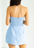 Light blue strapless dress worn by a person on a white background