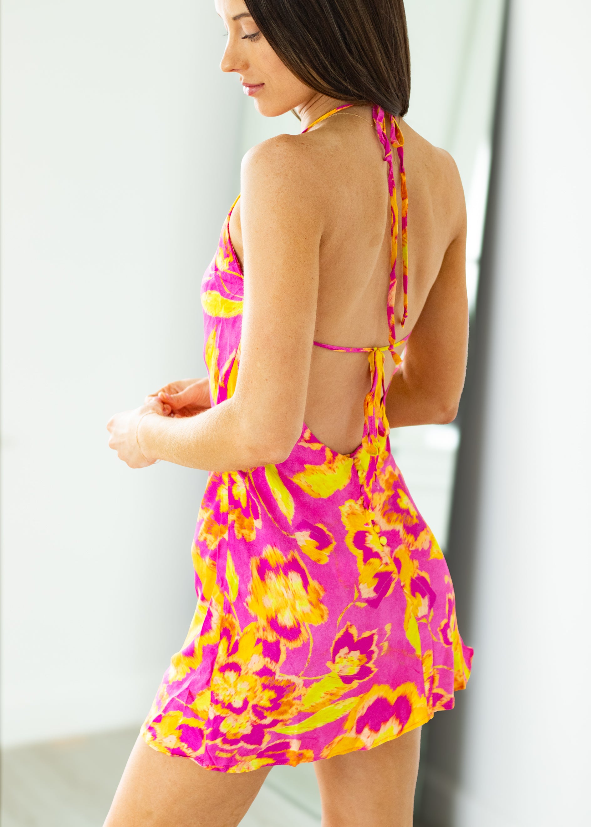 Woman wearing a pink floral dress on a white background

