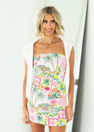 Woman wearing a strapless dress with a colorful floral pattern on a white background