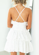 Woman wearing a white dress with cut-out design on a gray background