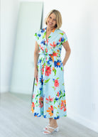 Woman wearing a colorful floral dress against a white background