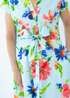 Colorful floral dress with a tie waist on a light blue background