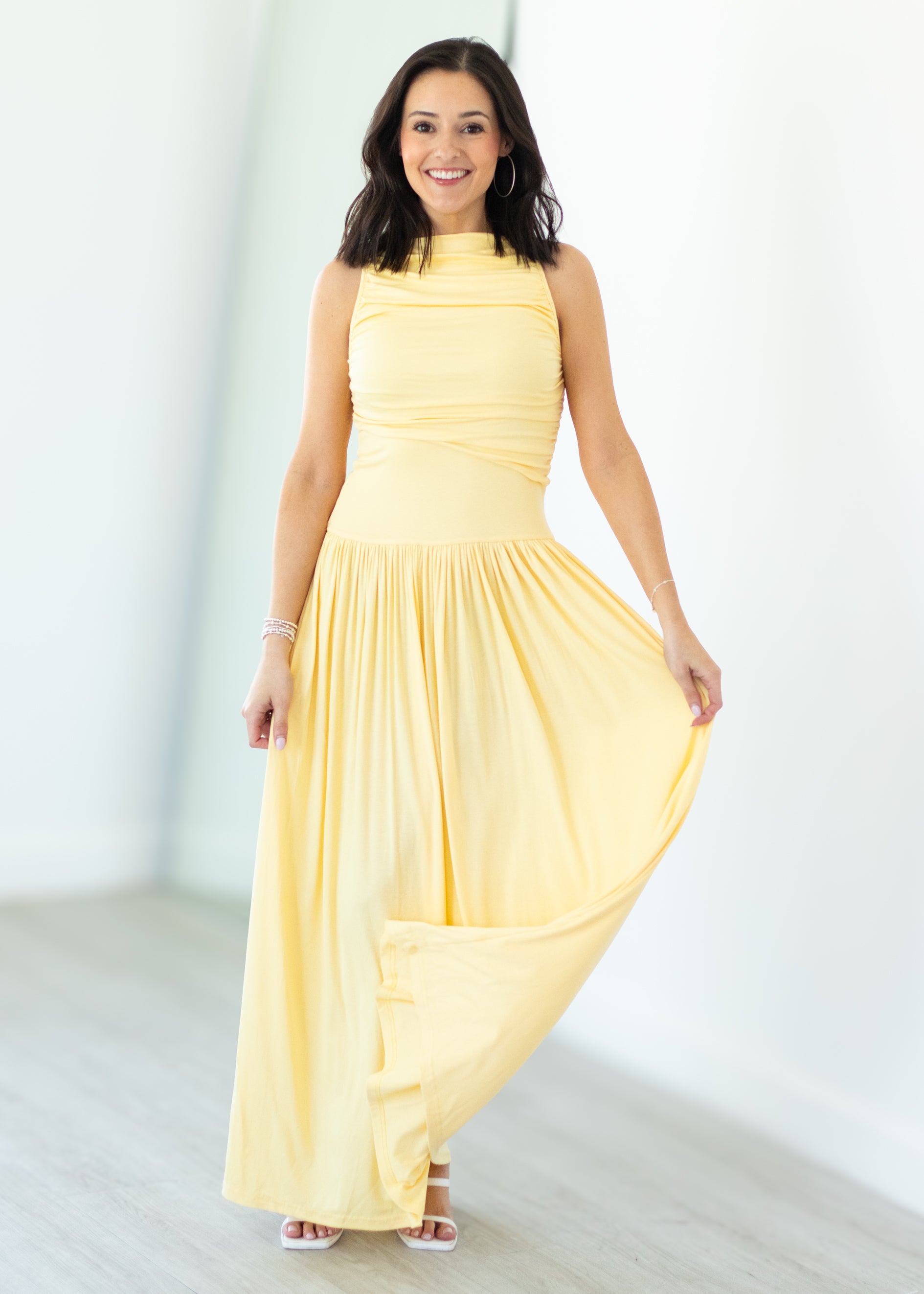 Woman wearing a yellow dress against a white background
