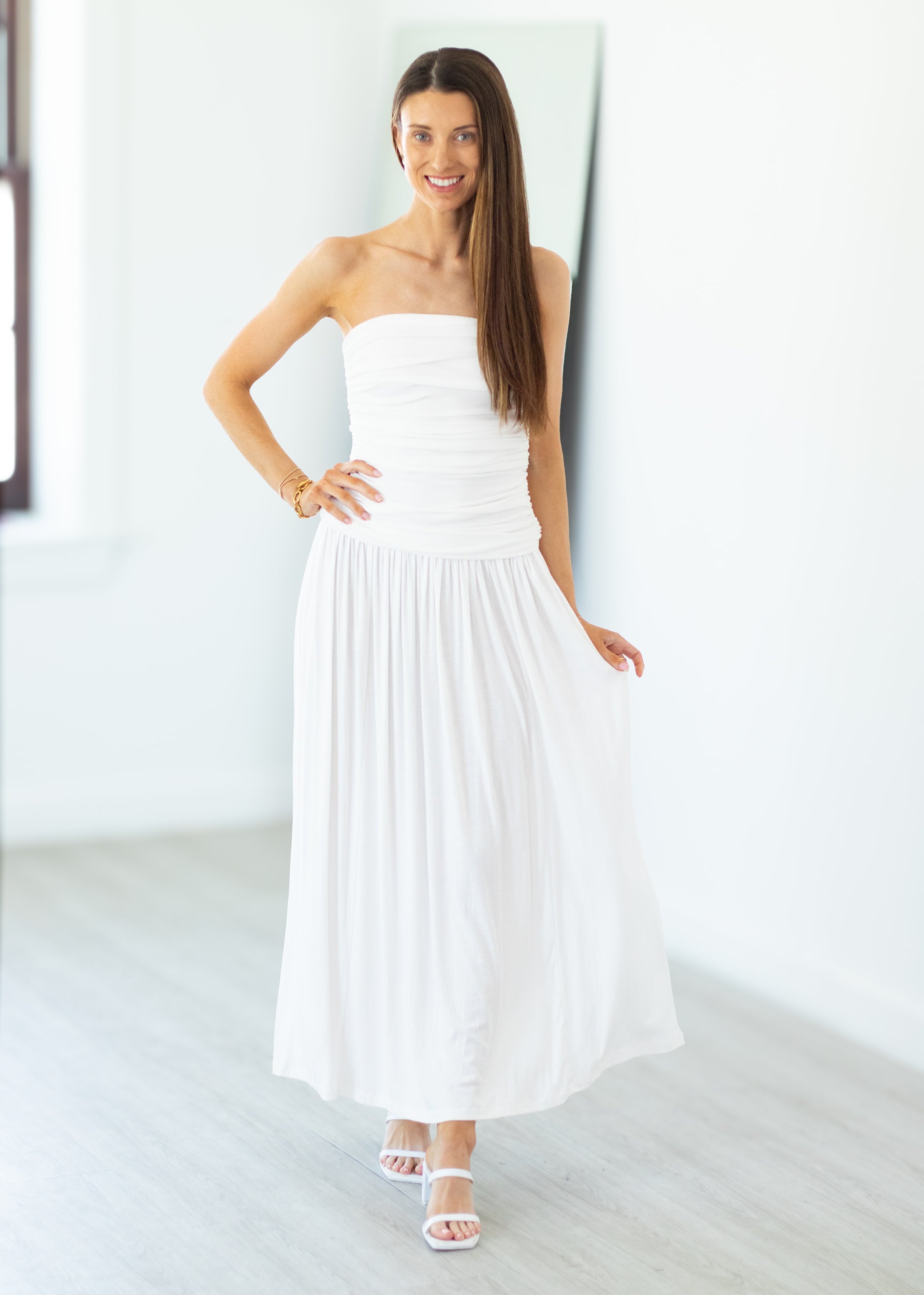 Woman wearing a white strapless dress in a minimalistic setting