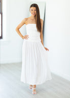 Woman wearing a white strapless dress in a minimalistic setting