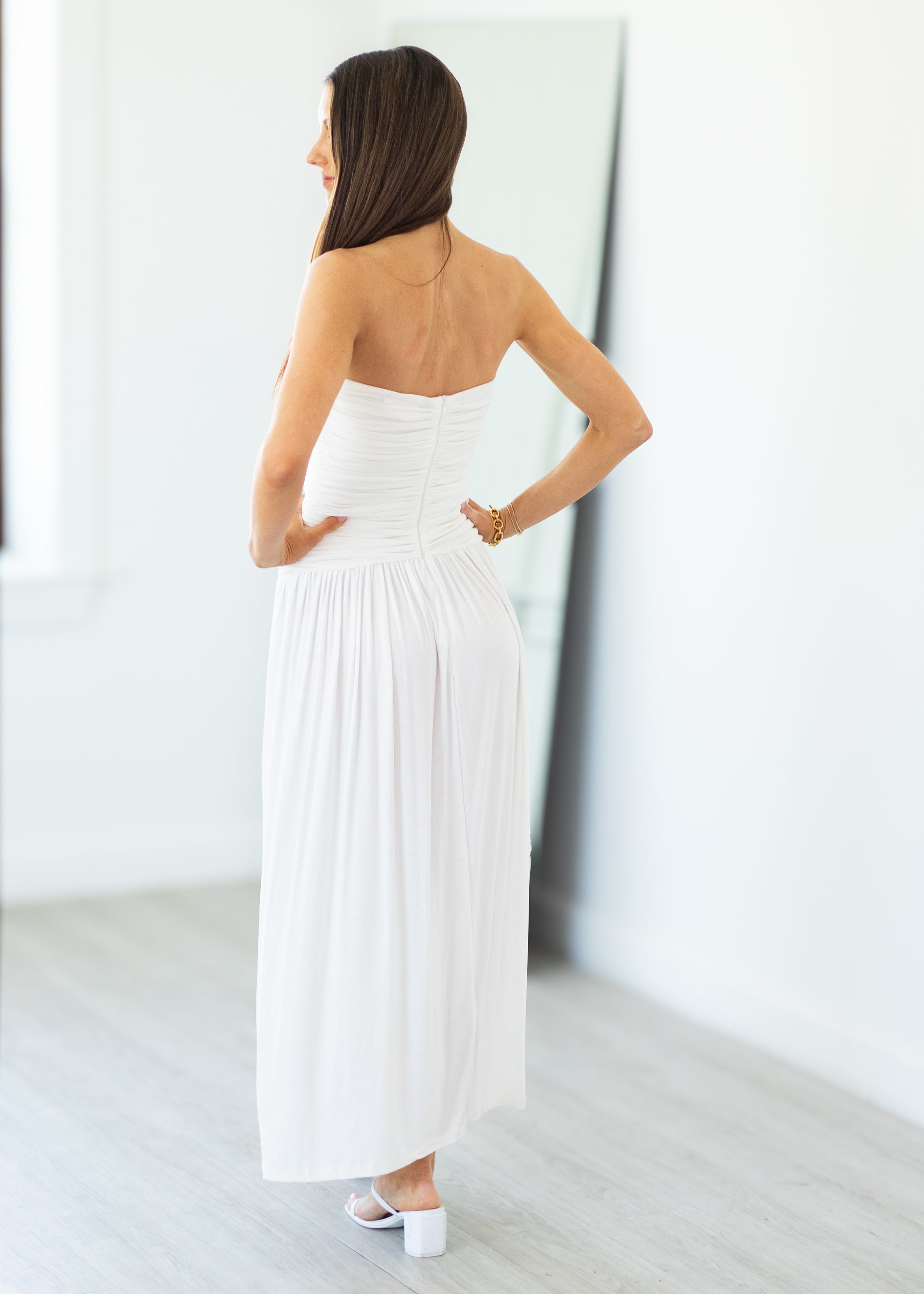 Woman wearing a white strapless dress in a minimalistic setting