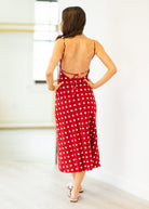 Woman wearing a red polka dot dress with a white background