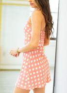 Woman wearing a pink polka dot dress with a blurred background