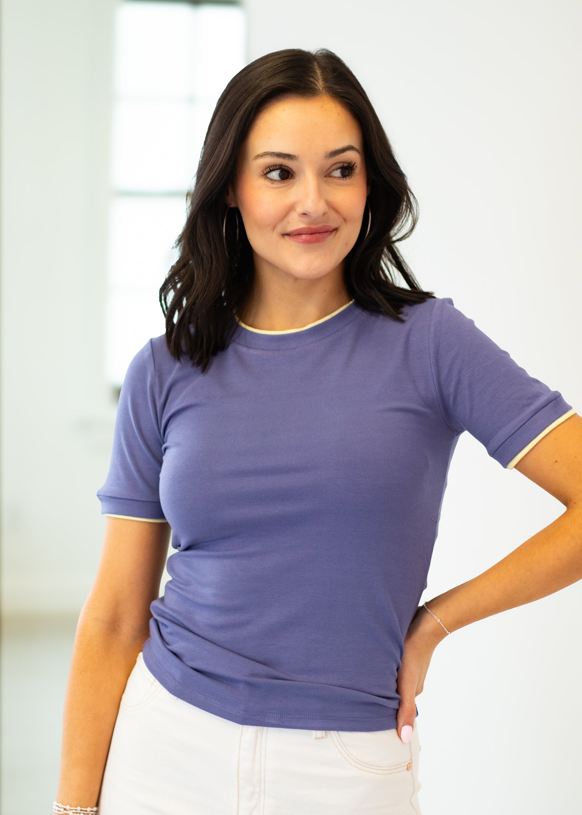 Woman wearing a purple t-shirt against a white background