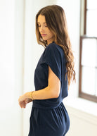 Woman wearing a navy blue outfit in a bright room