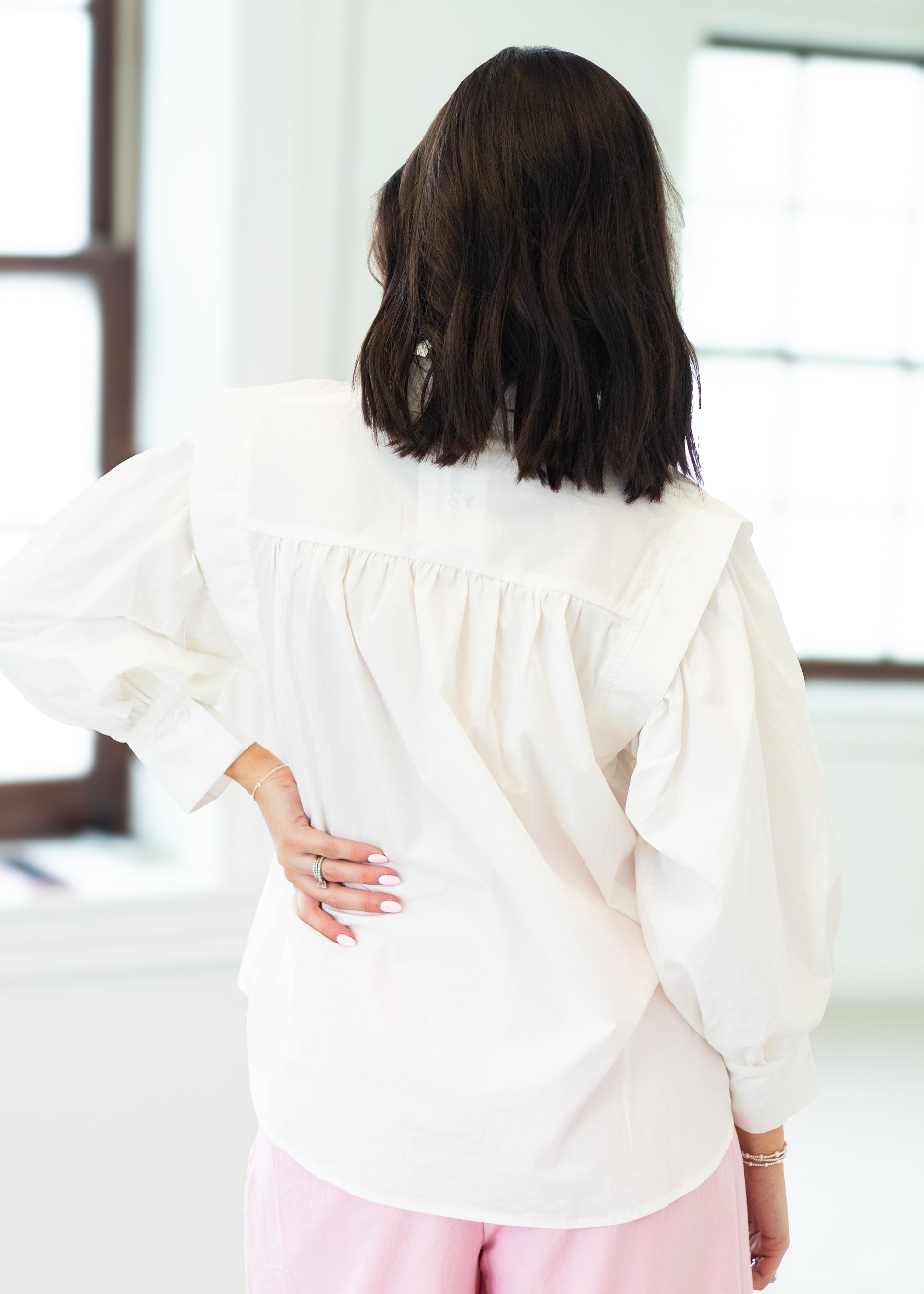 Person wearing a white blouse with a blurred background