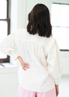 Person wearing a white blouse with a blurred background