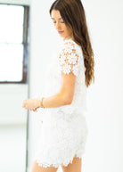 Woman wearing a white lace dress with a blurred background