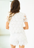 Woman wearing a white lace dress with a blurred background