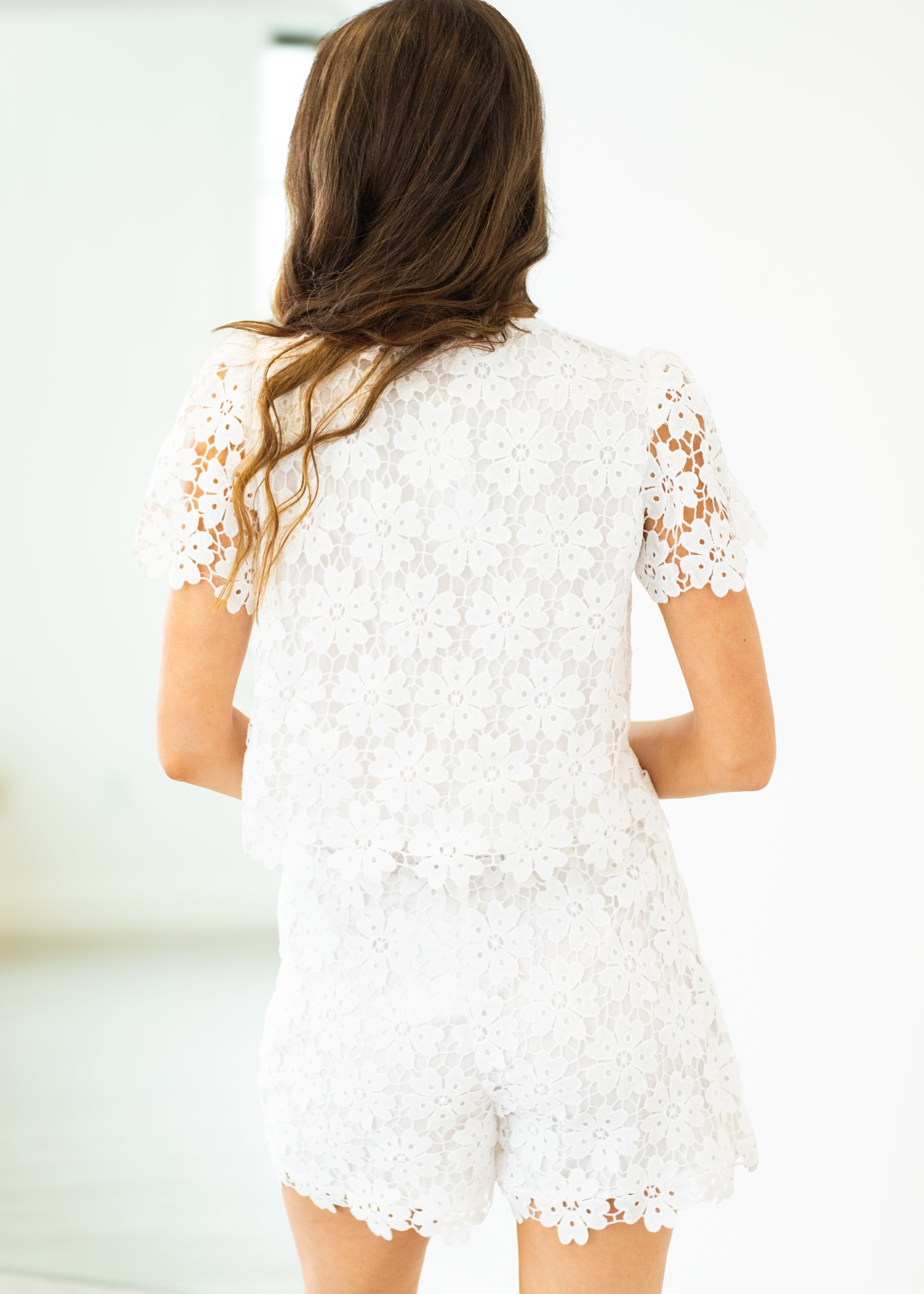 Woman wearing a white lace dress with a blurred background