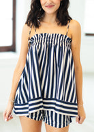 Woman wearing a navy and white striped romper with a blurred background