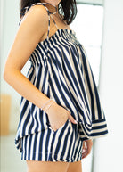 Person wearing a navy and white striped top with a blurred background