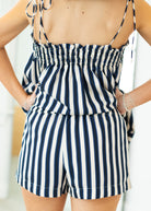 Woman wearing a navy and white striped romper with a blurred background